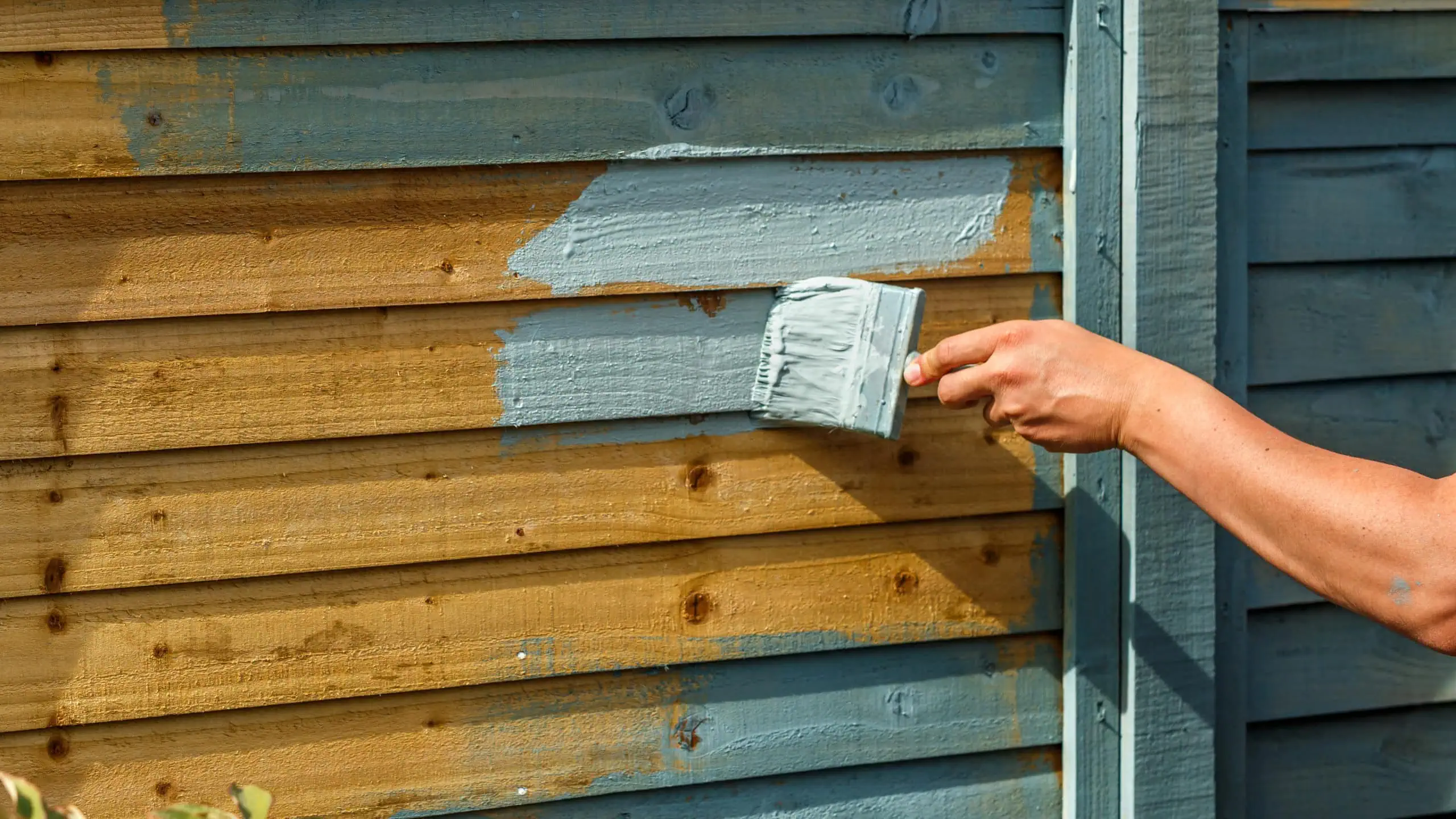 a person painting a wood wall