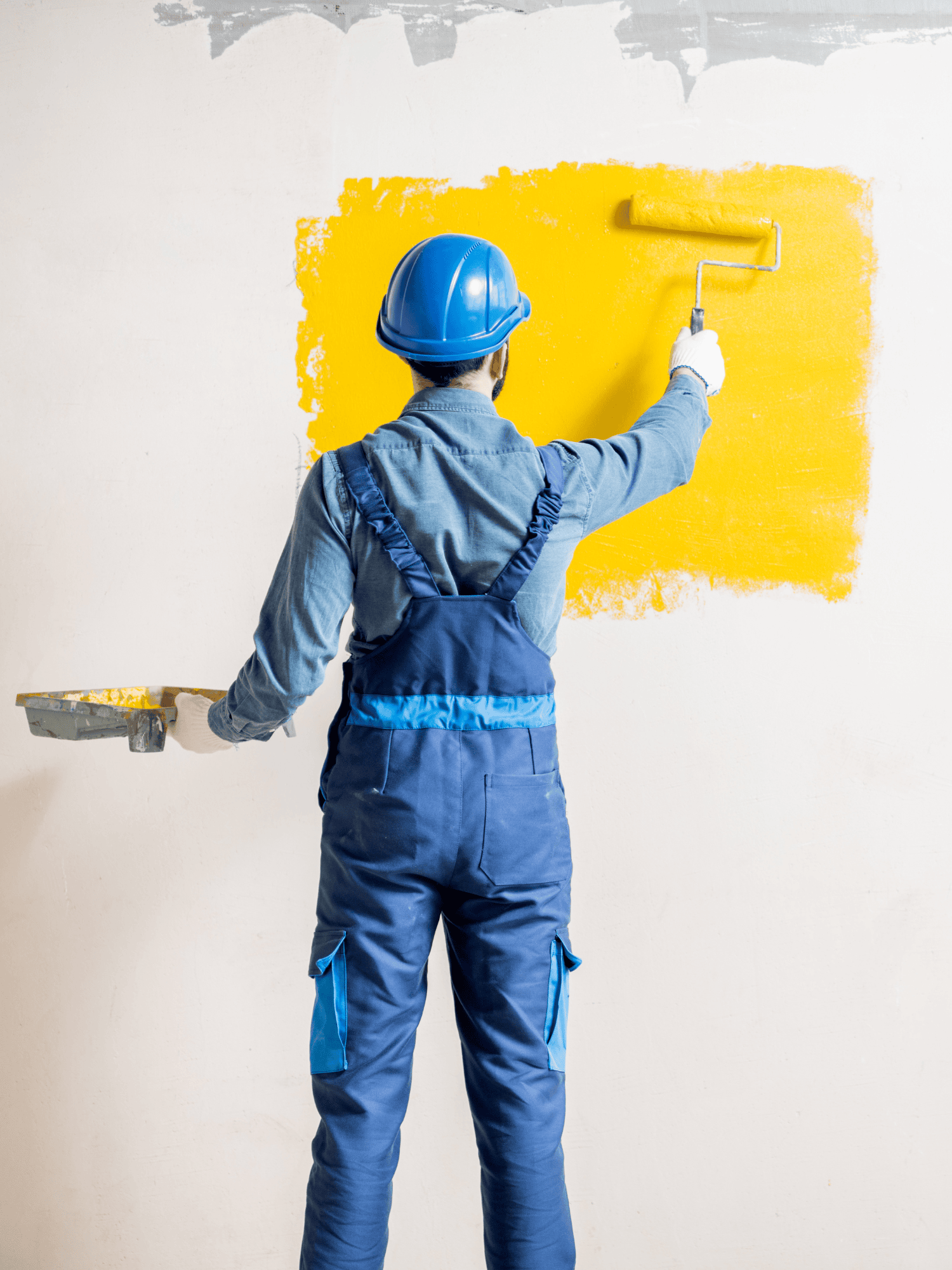 Worker skillfully painting a light blue wall, demonstrating professionalism and attention to detail.